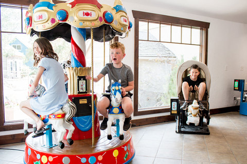  kids riding a mini carousel and covered wagon