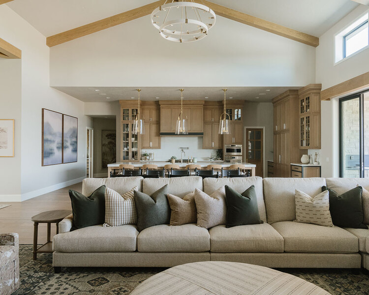 Down to Earth Projects | Utah Valley Parade at The Legacy at Meadow Ridge - Down to Earth Projects | Utah Valley Parade at The Legacy at Meadow Ridge - sectional in family room adjacent to kitchen