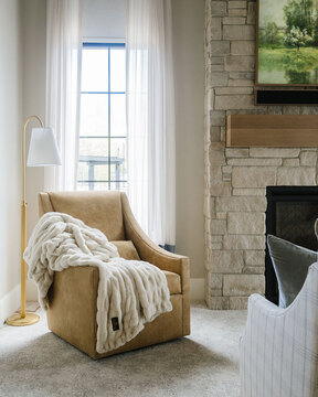 Down to Earth Projects | Utah Valley Parade at The Legacy at Meadow Ridge - camel chair with light next to fireplace 